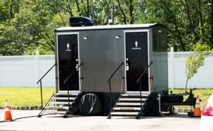 luxury porta potty trailer next to a fence