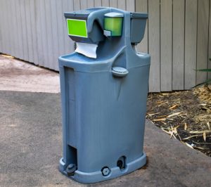 portable hand wash station next to a fence